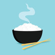 Rice in a bowl with chopstick isolated on blue background. Food for restaurant
