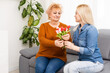 © Angelov - child daughter congratulates mother and gives a bouquet of flowers tulips