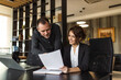 © bnenin - Friendly business partners looking at document in the office.