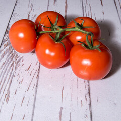 Tomatoes on a branch close-up on a white table, copy space, template