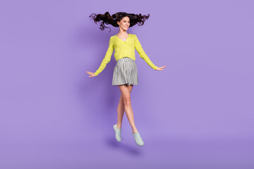 Wall Mural - Full size photo of optimistic nice brunette curly lady jump go wear sweater skirt sneakers isolated on purple color background