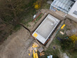 aerial drone shot of pool construction site almost finished spackling from above in a garden