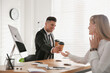 © New Africa - Man giving cup of coffee to his colleague in office. Flirting at work