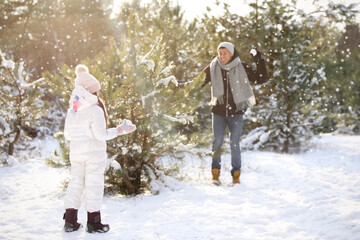 Poster - Father and daughter having snowball fight outdoors on winter day. Christmas vacation