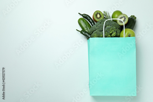 Obraz Dibond Paper bag with green vegetables on white background