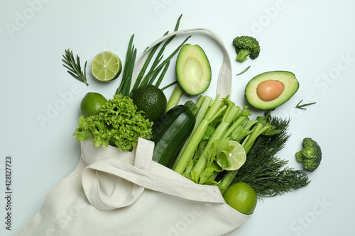 Obraz Dibond Cotton bag with green vegetables on white background