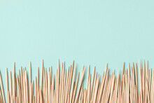 Wooden toothpicks on light blue background, flat lay. Space for text