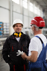 Wall Mural -  Portrait of workers in factory. Colleagues with helmet working in factory