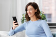 © Syda Productions - technology and people concept - smiling woman with smartphone at home