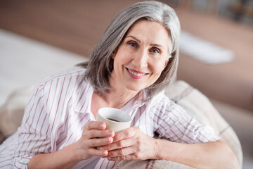 Sticker - Photo of positive pretty nice old woman hold cup of coffee smile drink good mood indoors inside house home