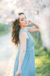 © Kristina89 - Beautiful young woman with curly hair is resting in the blooming sakura garden.