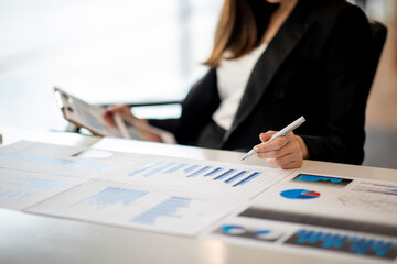 Financial Businesswomen analyze the graph of the company's performance to create profits and growth, Market research reports and income statistics, Financial and Accounting concept.