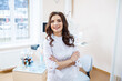 © DSMT - Dentist at the workplace. Cheerful doctor sits in a spacious modern office with a kind smile