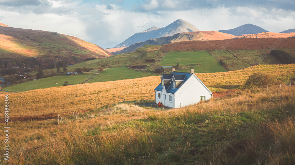 A lone traditional Scottish Highlands white croft house cottage in a rural mountain landscape countryside with Glamaig Peak and the Red Cuillins on the Isle of Skye, Scotland. - obrazy, fototapety, plakaty 