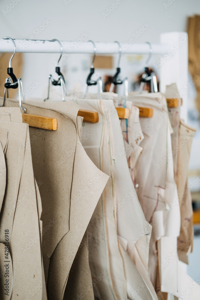 Many paper sewing patterns for different clothes hanging on the 