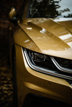Vertical Shot Of The Headlight Of The Matte Gold Car