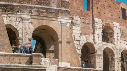 Wall Mural - Many tourists visiting The Colosseum or Coliseum timelapse, also known as the Flavian Amphitheatre in Rome, Italy. People on top, close up view