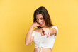 © luismolinero - Young caucasian woman isolated on yellow background making phone gesture and pointing front
