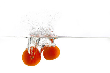 two ripe orange tangerine falls into the water with splashes on a white background, isolate