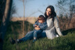 © nicoletaionescu - Mother Sitting in Nature with Her Child Relaxing Outdoors