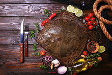 Flounder Fish On Wood Background With Spices And Vegetables