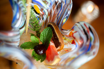 Sticker - Top view of a cocktail in colorful glass with orange and dried lemon slices, mint and fir branch