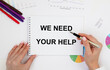 © Veranika - The girl holds a notebook in front of her with we NEED YOUR HELP tacts, pencils and reports.