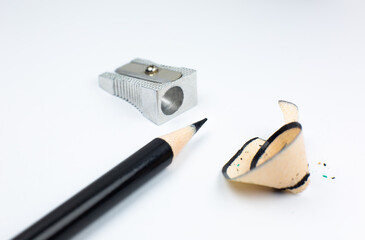 Sharpener and a broken pencil. Shavings and a graphite on white background. Close up, Macro photo.