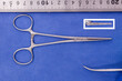 crile forceps (haemostats) with inset jaw pattern on a blue background
