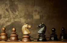 Wooden Knights Chess Pieces Facing Each Other On A Vintage Chessboard, Rivalry Concept.