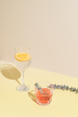 Two summer cocktails on a yellow beige background. Concept of a party and summer sunny day with a copy space.