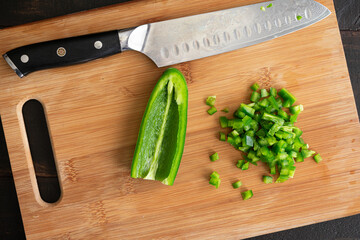 Wall Mural - Minced Jalapeño Pepper on a Cutting Board: Minced green chili pepper on a wooden chopping board