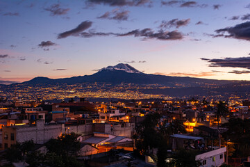 Wall Mural - Chimborazo Volcano next to a beautiful city at a beatiful sunset
