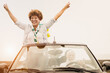Happy senior couple having fun in summer vacation with cabriolet car - Elderly multiracial people inside convertible car