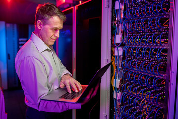 Poster - Mature IT engineer working with server