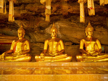 3 Golden Statues In The Cave At Tham Khuha Sawan Temple. Ubon Ratchathani, Thailand.