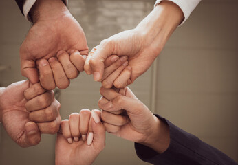 Wall Mural - view from bottom (worm eye view) of multiethnic business team touching hands together as a sign of unity in internation corporate office. diversity in business concept