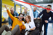 © maxbelchenko - Friendly work team  ride chairs in office room cheerfully excited diverse employees laugh while enjoying fun work break activities, creative friendly workers play a game together.