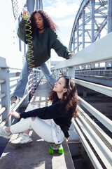 Wall Mural - young cute teenage girls together in industrial zone happy smiling having fun, big city lifestyle fashion people