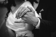 Grayscale shot of a newlywed couple showing their rings