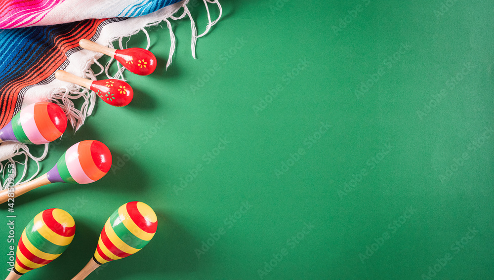 Cinco de Mayo holiday background made from maracas, mexican blanket stripes or poncho serape on green background. - obrazy, fototapety, plakaty 