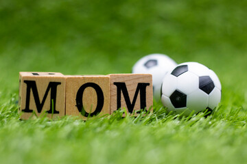 Soccer ball with word mom are on green grass