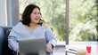 © Bangkok Click Studio - Asian young happy beautiful plus size sexy fat chubby smart female model sit relaxing on sofa smiling look at camera using laptop computer work from home in quarantine time from covid pandemic moment