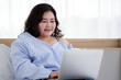 © Bangkok Click Studio - Asian young happy fat chubby woman lay down have fun laughing happily lean on white pillow on bed using laptop computer to watch movie and eat popcorn on quarantine lockdown on covid pandemic at home