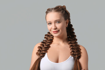 Canvas Print - Beautiful young woman with braided hair on grey background