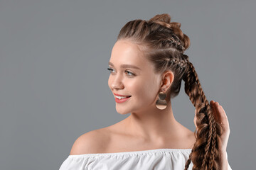 Canvas Print - Beautiful young woman with braided hair on grey background