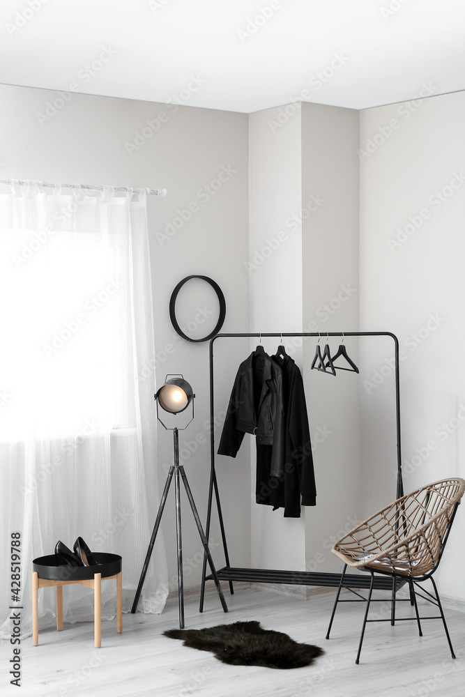 Interior of modern room with lamp and stylish clothes