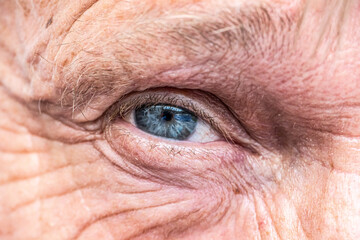 Close-up macro view on the blue eye of senior man smiling