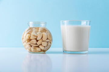 Process of soaking various nuts: hazelnuts in water to activate and glass of vegetable milk. Home Cooking: making plant based organic veggie Milk, lactose free