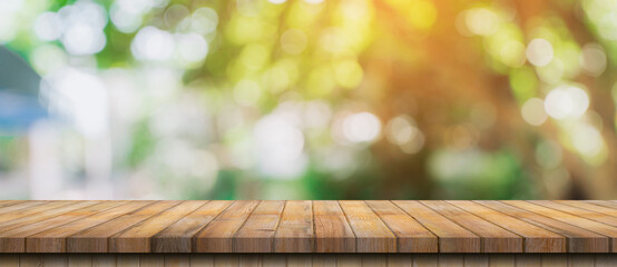 Empty wood table and defocused bokeh and blur background of garden trees with sunlight. product display template.